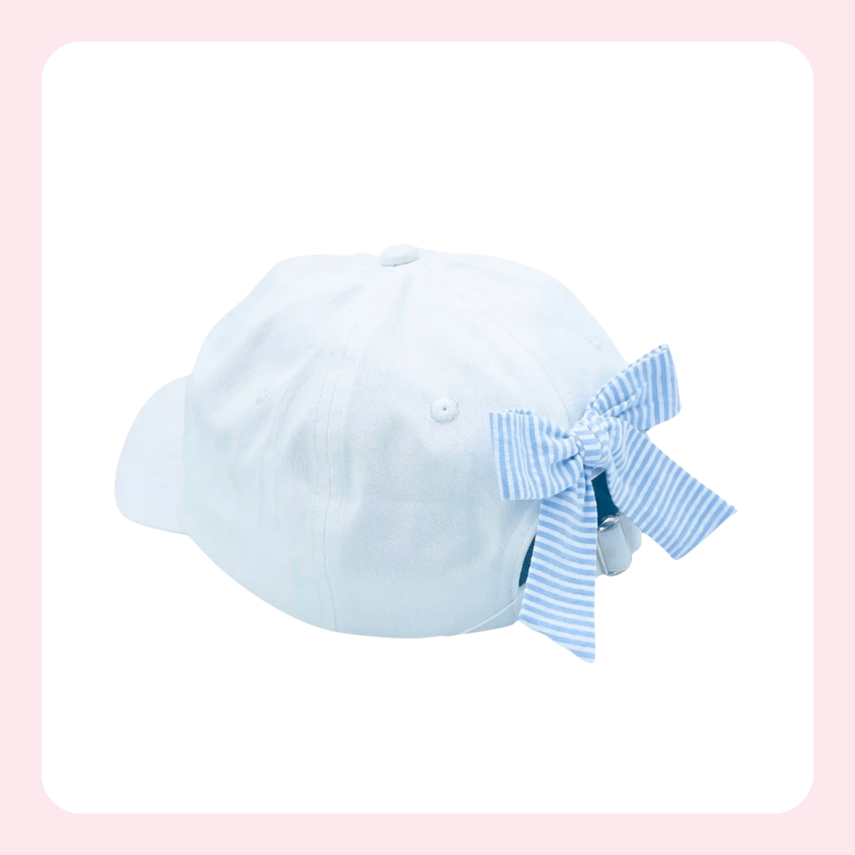 A white baseball cap with a light blue and white striped ribbon bow tied on the side, shown against a white background with a soft pink border.