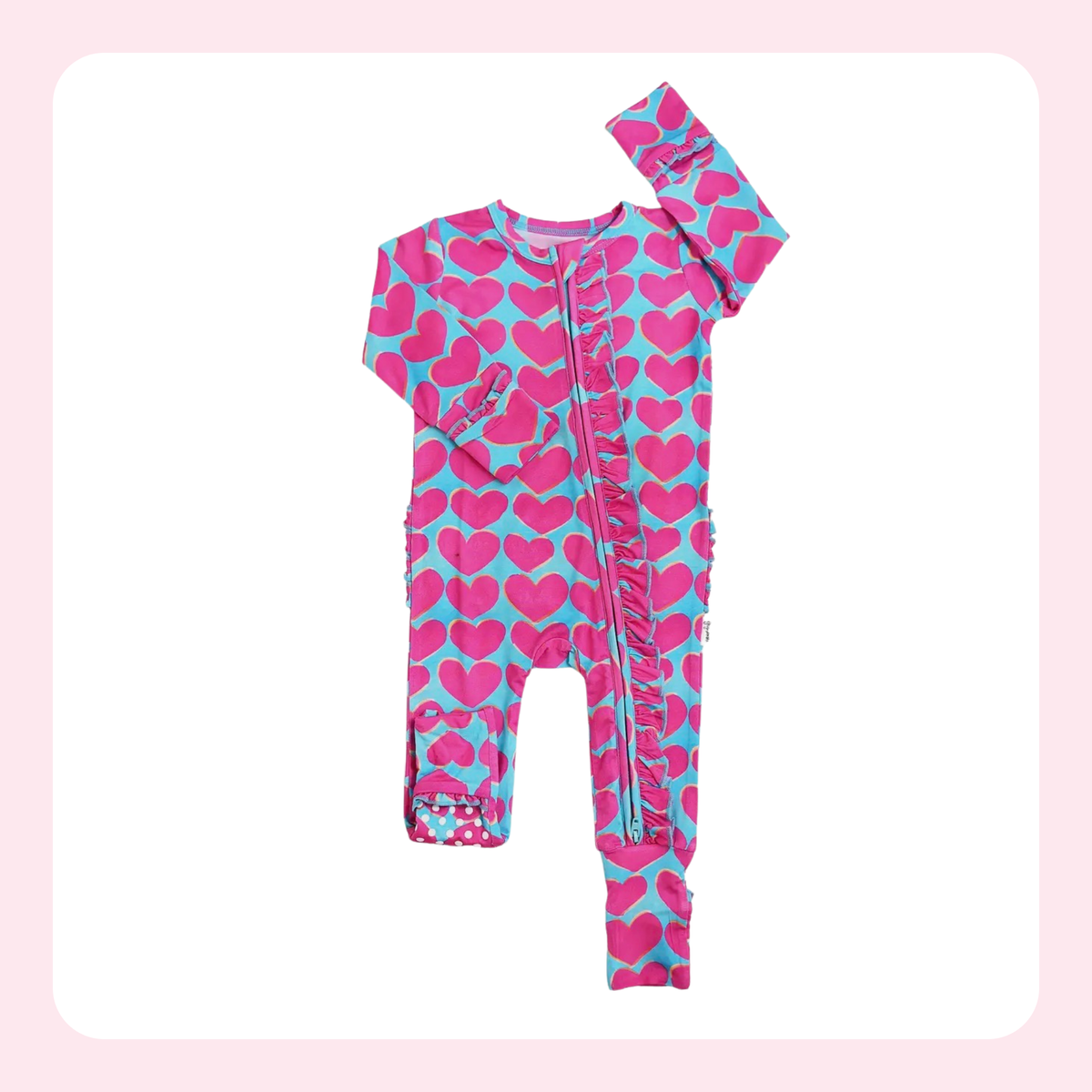 Children's onesie with pink heart pattern on a light pink background