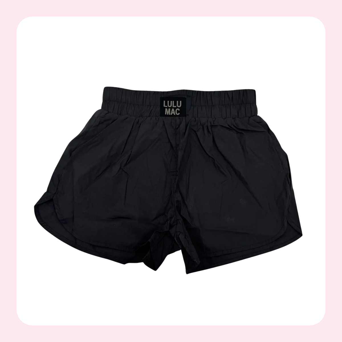 Black athletic shorts with an elastic waistband and a small black label reading 'LULU MAC' on the front, shown against a white background with a light pink border.