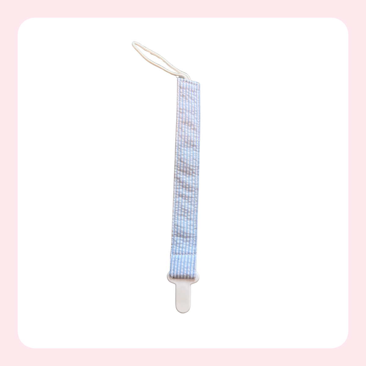 A baby pacifier clip with a light blue and white checkered patterned fabric strap and a white plastic clip, shown on a white background with a soft pink border.