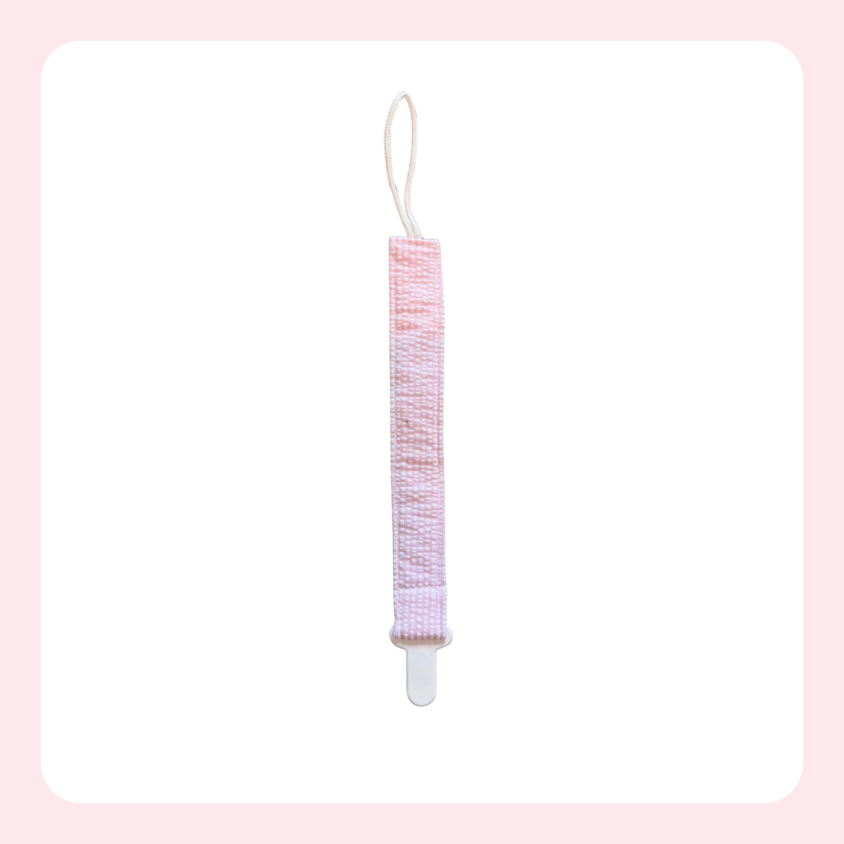 A pink and white patterned fabric hair tie or hair accessory with a white plastic clip and a white loop string, shown against a white background with a light pink border.