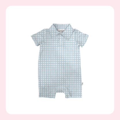 A baby short-sleeve romper with a light blue and white gingham check pattern, featuring a polo-style collar and snap-button placket, shown on a white background with a soft pink border.