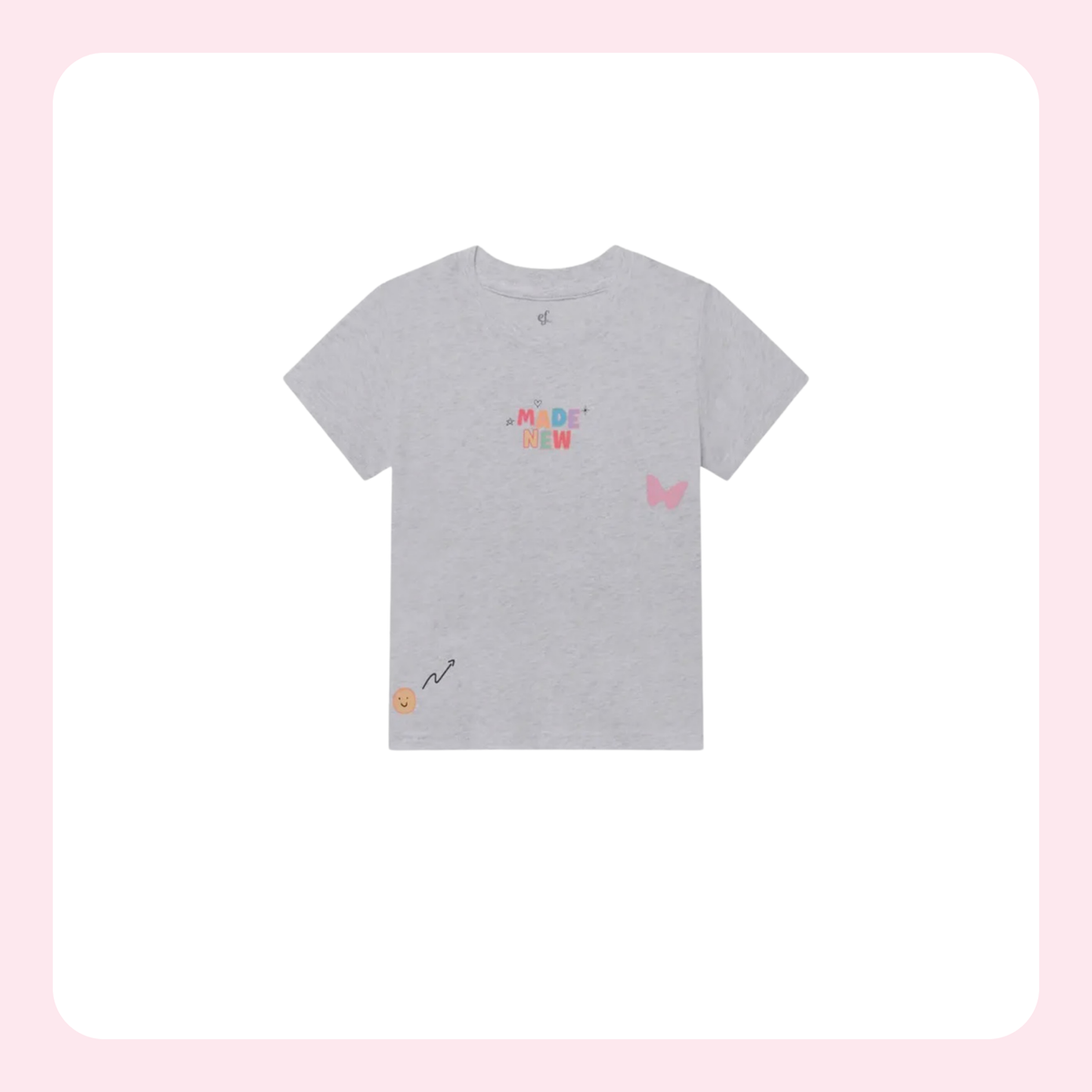 A light gray heather short-sleeve t-shirt with colorful graphic prints, including the text 'MADAME NEW' in pastel colors, a pink butterfly on the right chest, and a small yellow smiley face with a black squiggle on the bottom left hem, displayed on a white background with a soft pink border.