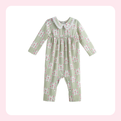 A baby long-sleeve romper in sage green with a pink and white floral pattern, featuring a Peter Pan collar and a smocked chest detail, shown on a white background with a soft pink border.