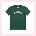 A dark green short-sleeve crewneck t-shirt with 'BASEBALL' and 'LIFESTYLE' printed in white arched text on the chest, displayed on a white background with a light pink border.
