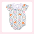 A baby romper with a white base, featuring a repeating pattern of orange and pink pumpkins, green leaves, and light blue bows, finished with a light purple collar.