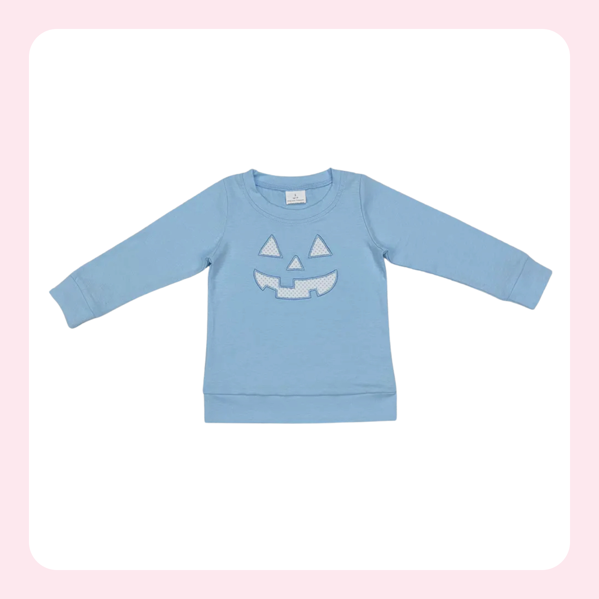 A light blue long-sleeve crewneck sweatshirt featuring a white embroidered jack-o'-lantern face on the front, displayed flat against a white background with a soft pink border.