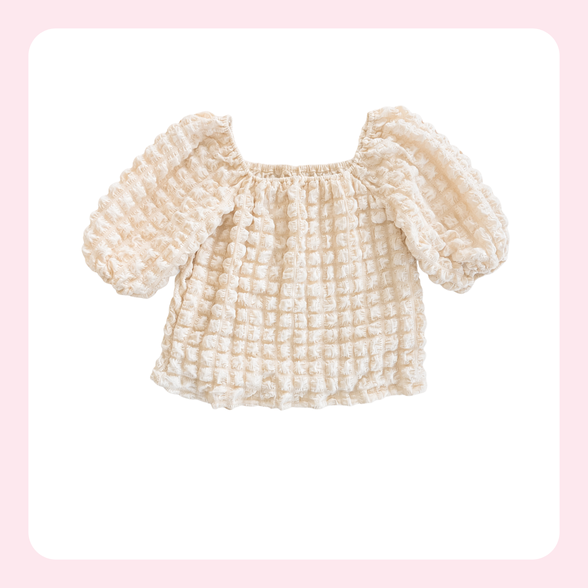 A cream-colored textured baby top with puff sleeves and a square neckline, displayed on a white background with a soft pink border.