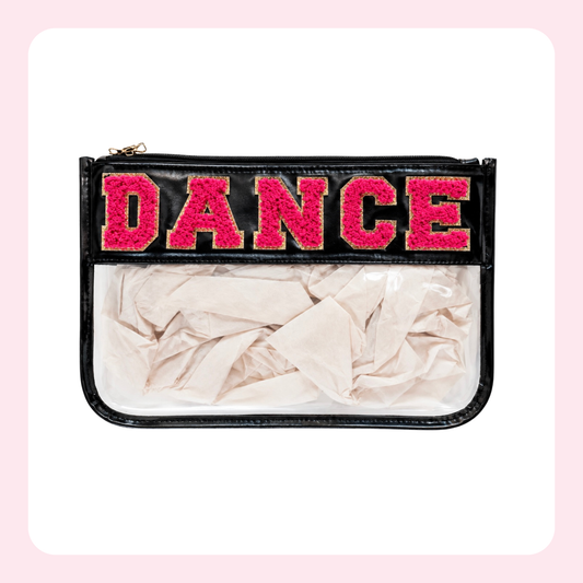 A rectangular zippered pouch with a black faux-leather border and a clear front panel. The top band is black with the word "DANCE" in large pink letters outlined in gold.