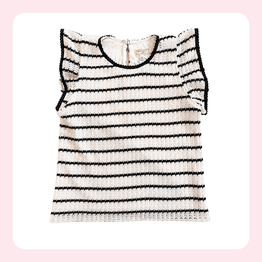 A sleeveless knit top with horizontal black stripes on a cream background, featuring ruffled sleeves and a crew neckline, shown against a light pink background with a white rounded square.
