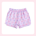 A pair of children's shorts with an elastic waistband, featuring a light pink and white base with a small pink and purple floral pattern, displayed on a white background with a soft pink border.