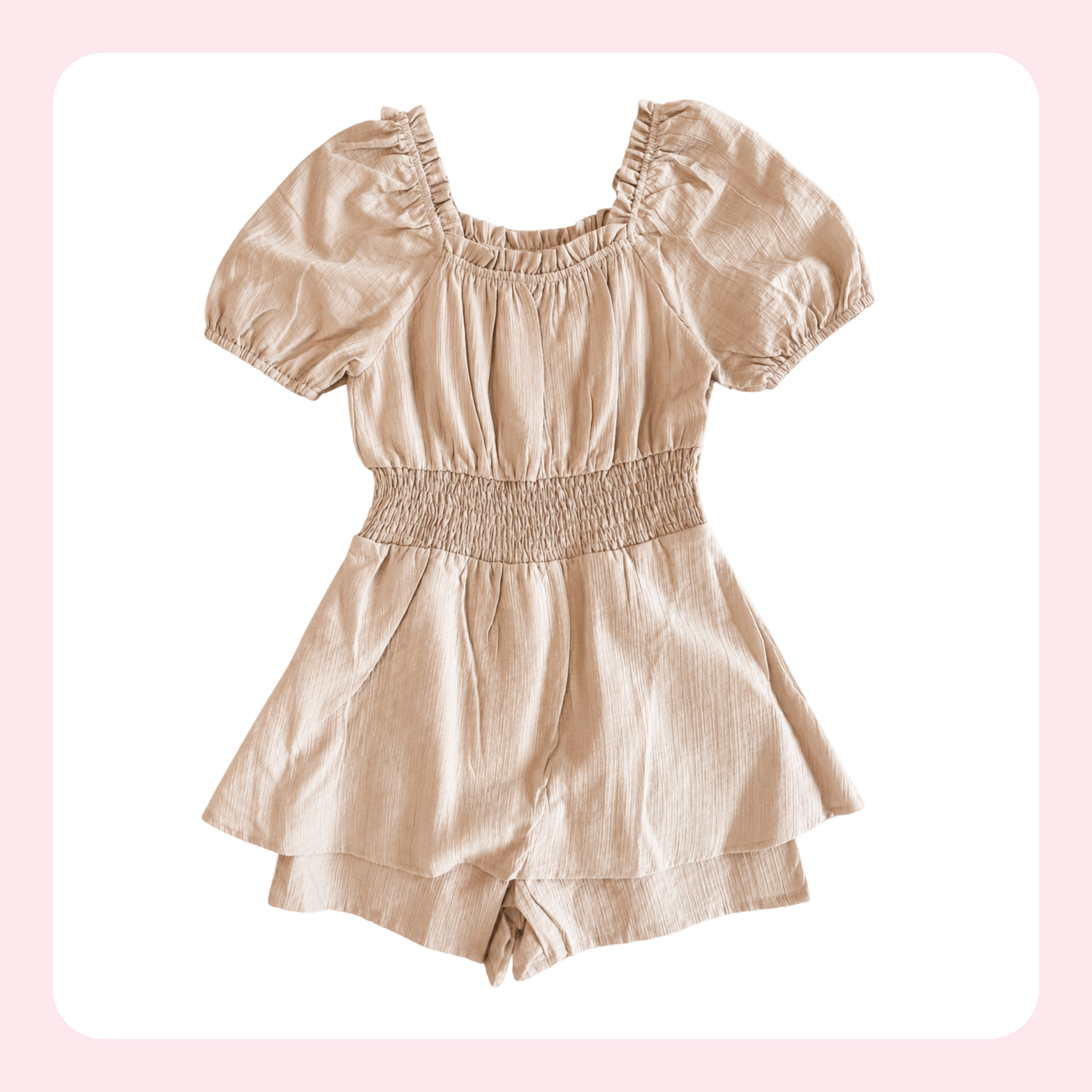 A light beige linen romper with short puff sleeves, a smocked waist, and a square neckline, displayed on a white background with a soft pink border.