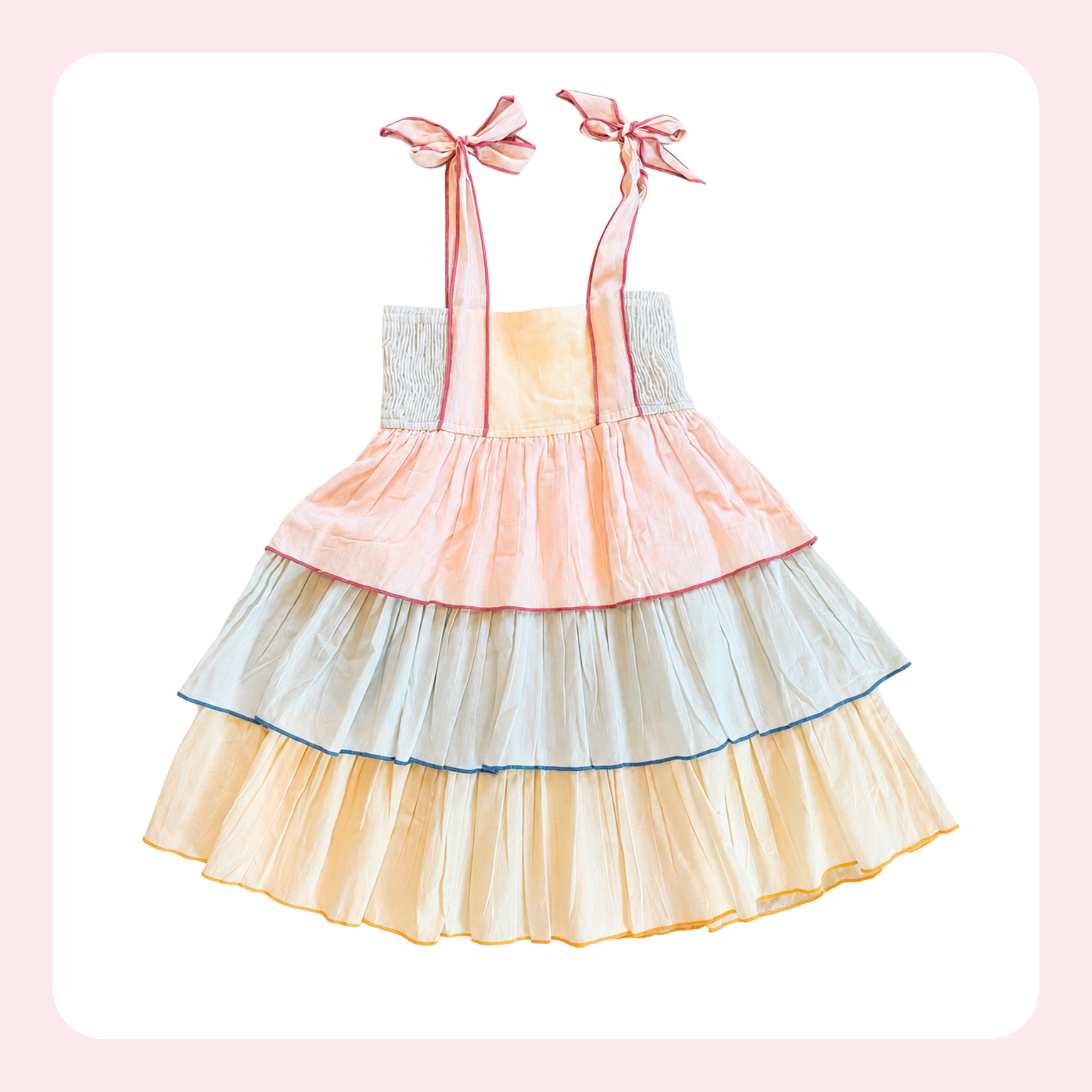 A pastel tiered babydoll dress with pink ribbon shoulder straps tied in bows, featuring layers of peach, pale blue, and cream ruffles with thin colored trim.