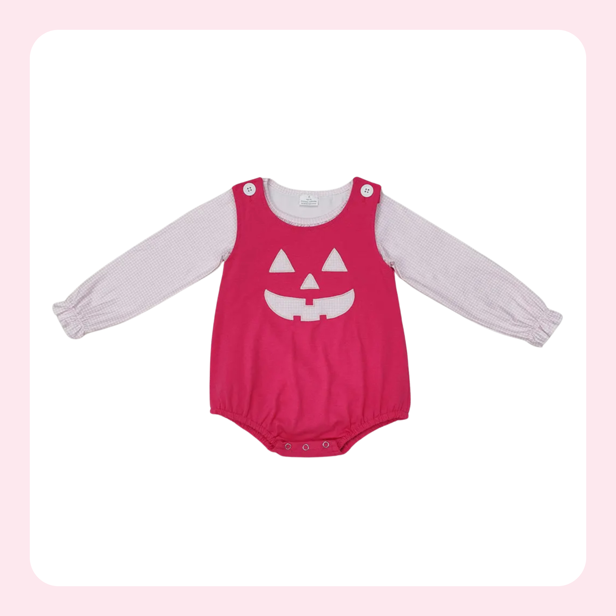 A baby long-sleeve bodysuit featuring a bright pink front panel with a white jack-o'-lantern face graphic, layered over a light pink ribbed long-sleeve shirt, displayed on a white background with a soft pink border.