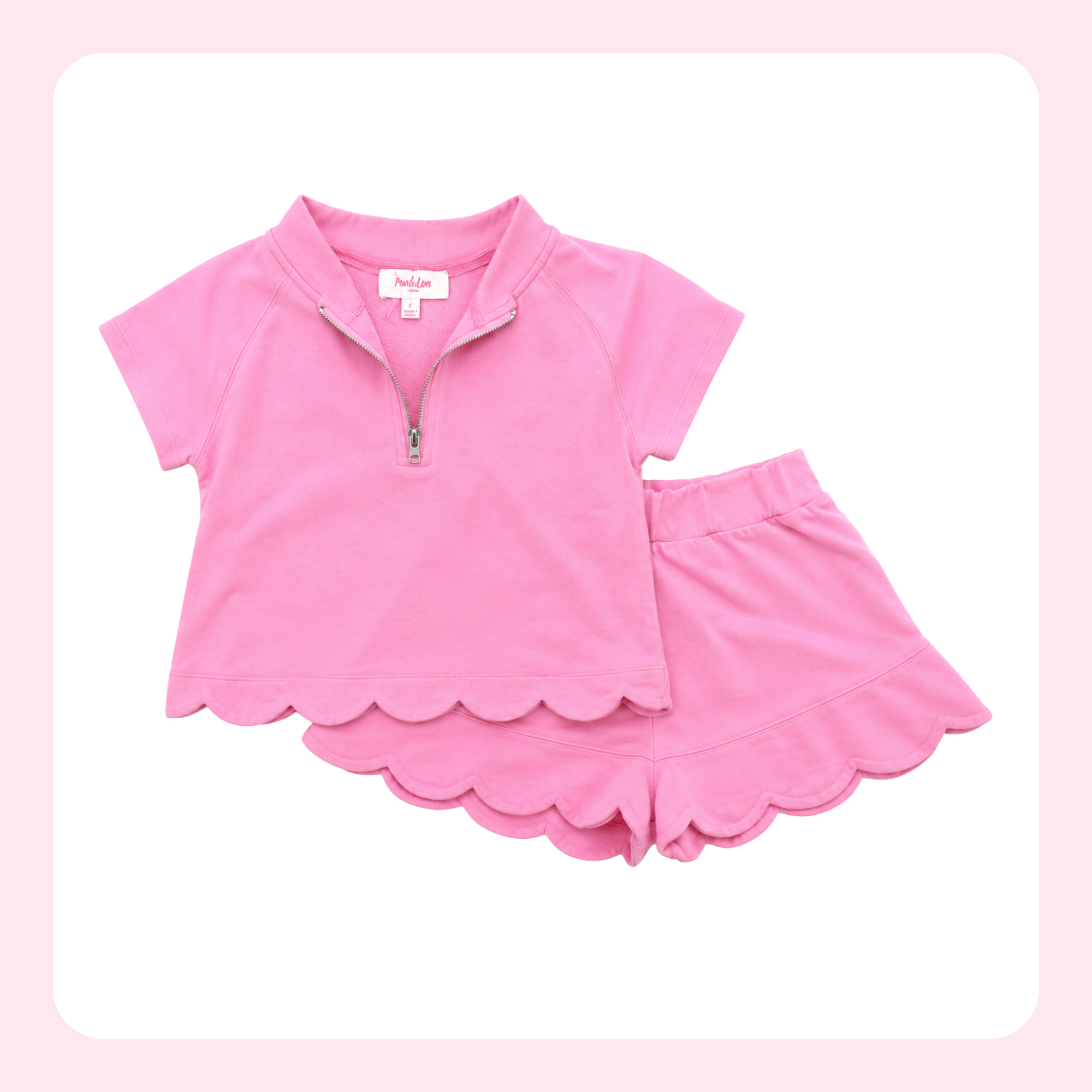 A pink two-piece girls' outfit set featuring a short-sleeve quarter-zip top with a scalloped hem and matching scalloped shorts, displayed on a white background with a light pink border.